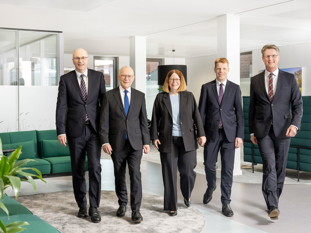 Das Bild zeigt den fünfköpfigen Vorstand der Volksbank Kassel-Göttingen in einem Büro. Alle Personen tragen einen Anzug. In der Mitte ist die einzige Frau im Vorstand zu sehen. Links und rechts von ihr jeweils zwei Männer. Von links nach rechts zu sehen sind: Hans-Christian Reuß, Volker Stern, Kerstin Orth, Thorsten Schartel und Wolfgang Osee