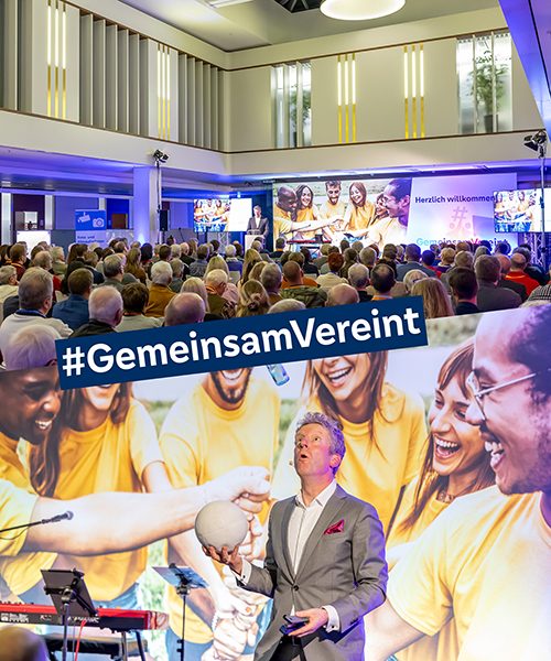 Das Bild ist zweigeteilt und in der Mitte steht "#GemeisamVereint". Im oberen Bild ist ein Veranstaltungssaal mit vielen istzenden Menschen zu sehen, die in Richtung Bühne schauen. Darunter ist eine Person in einem hellgrauen Anzug zu sehen, die in einer Hand einen weißen Ball hält und in der anderen Hand einen anderen Gegenstand. Dabei schaut sie konzentriert nach oben auf ein anderes Objekt, das sich in der Luft bewegt. Er jongliert vermutlich mit diesen Gegenständen.